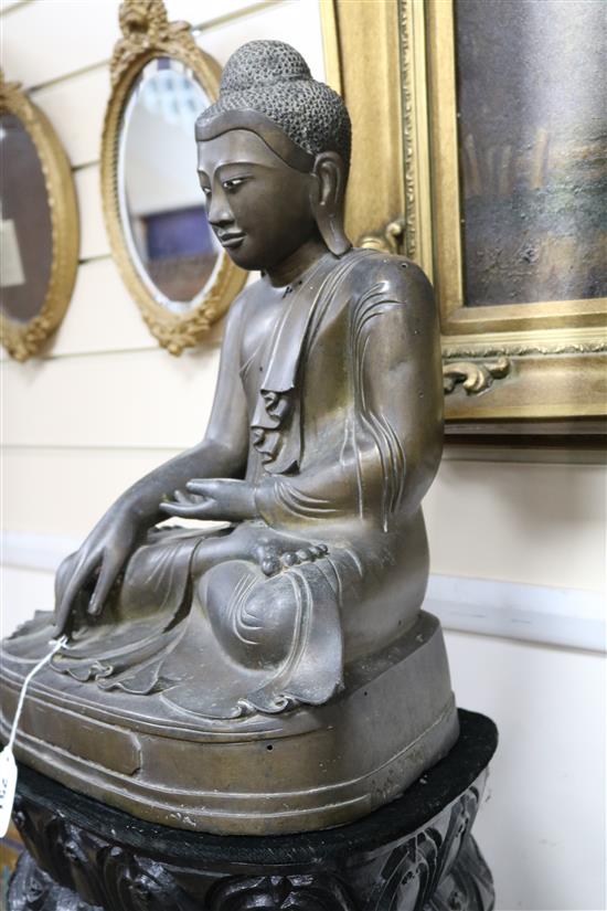 A 19th century Burmese bronze Buddha inset ebony and ivory eyes seated on bespoke lotus-carved polished wood column